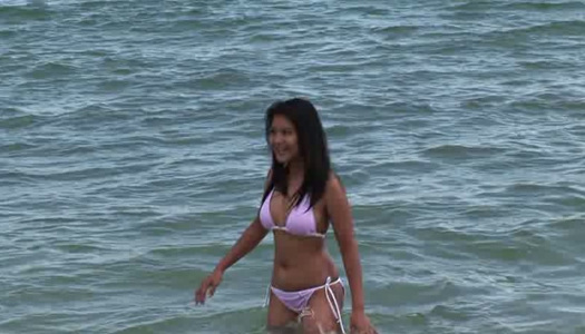 Happy smiling Asian brunette swims in the ocean and poses in her bikini porn pics